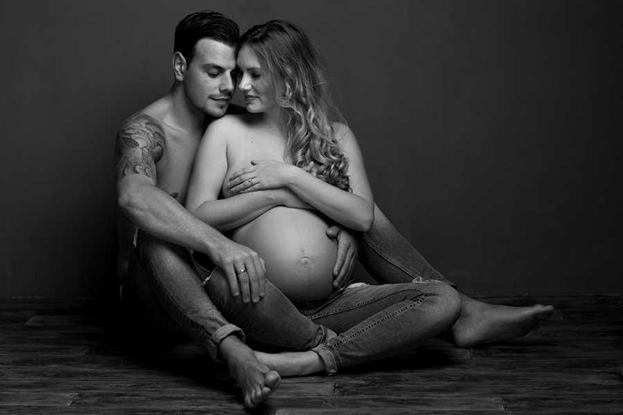 zwart/wit zwangerschap fotoshoot samen met partner zittend op de grond in jeans